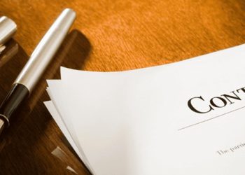 “Doctor reviewing physician agreement to avoid legal mistakes.”